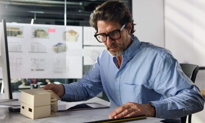 Ein Architekt in einem modernen Büro arbeitet konzentriert an Bauplänen.