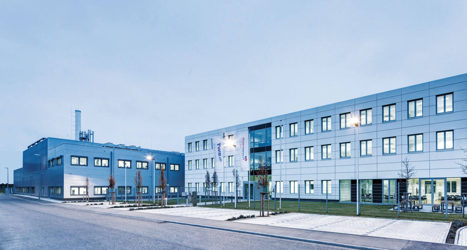 Die Aufnahme zeigt ein modernes Büro- und Industriegebäude mit großen Fenstern und klaren Linien.